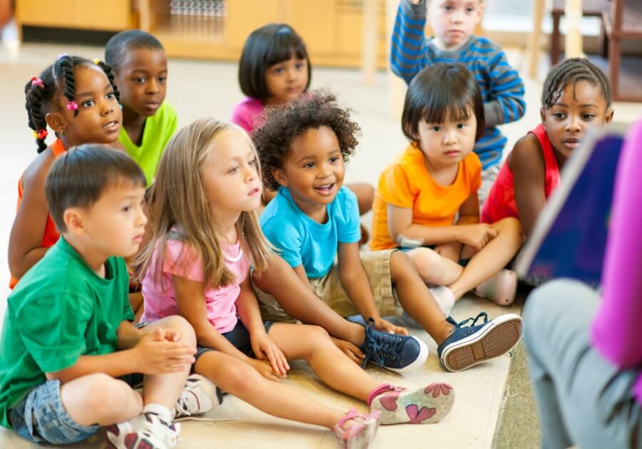 elementary school children sitting on floor during lesson