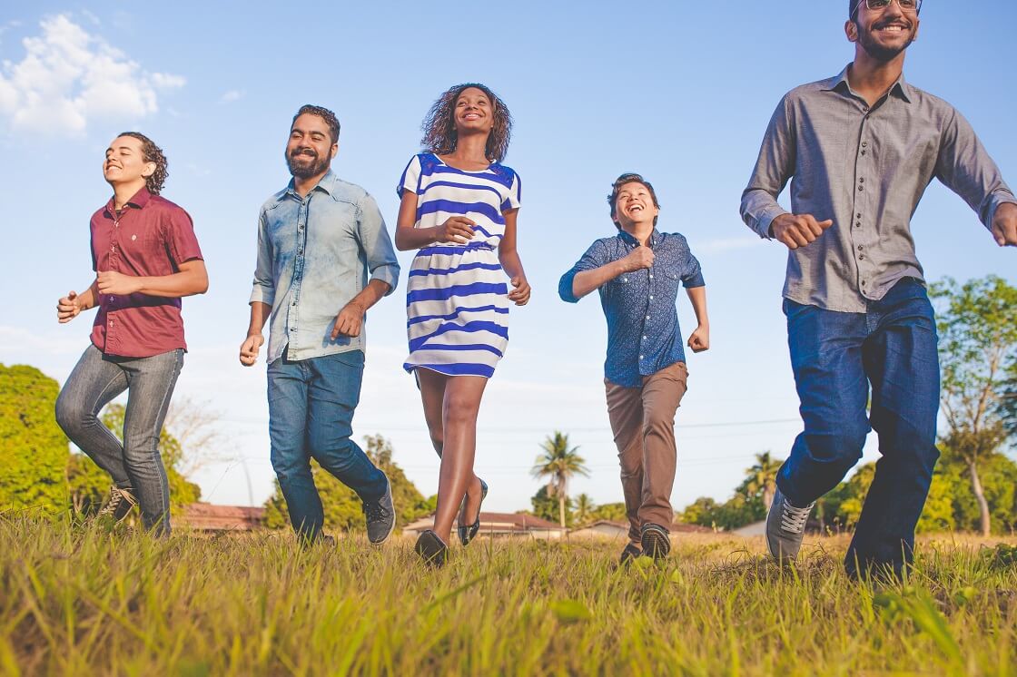 diverse group of older students running in field