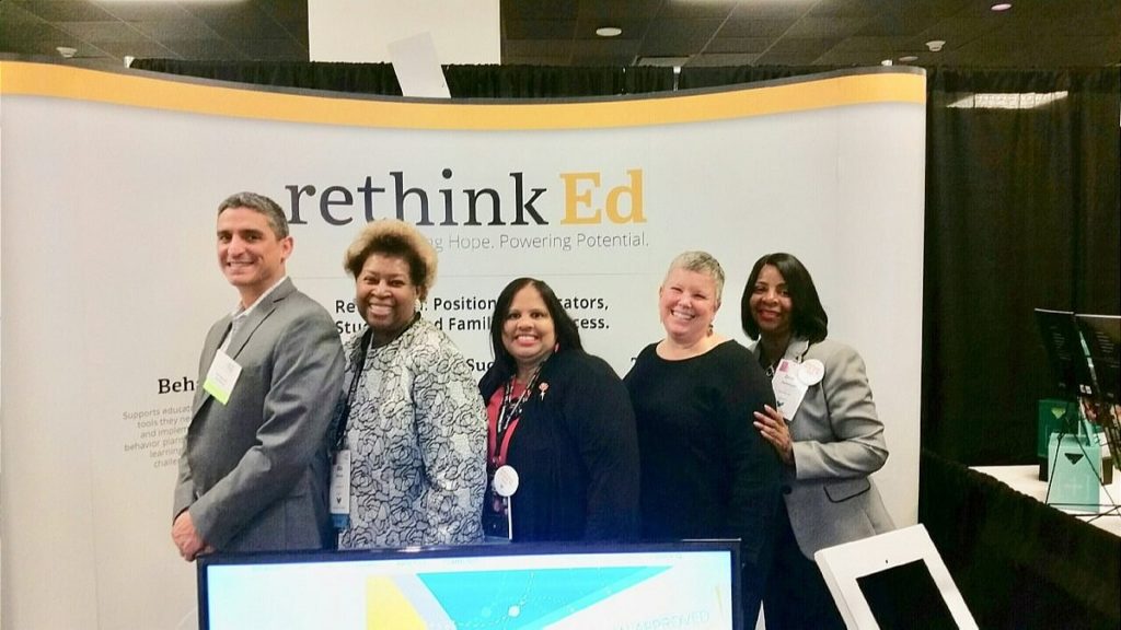 RethinkEd Team Members and Experts posing in front of RethinkEd banner
