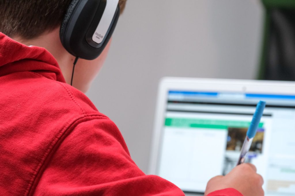 Student wearing headphones while remote learning at home