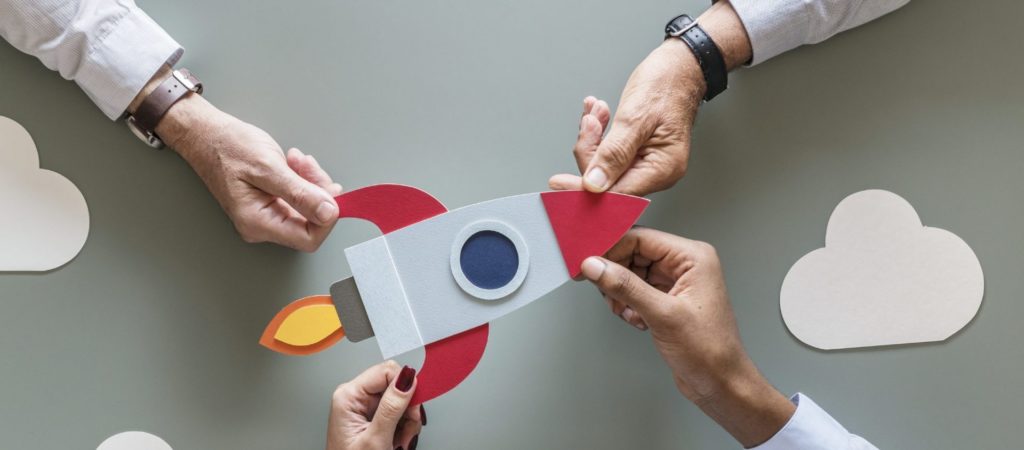 People holding paper spaceship