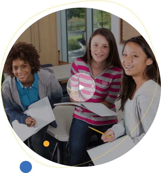 African American boy and two girl middle school students laughing in class with notebooks