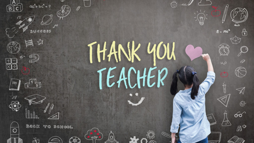 Girl student writing Thank You Teacher on chalkboard along with doodles