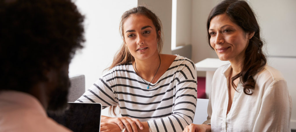 Mother and daughter talking to teacher