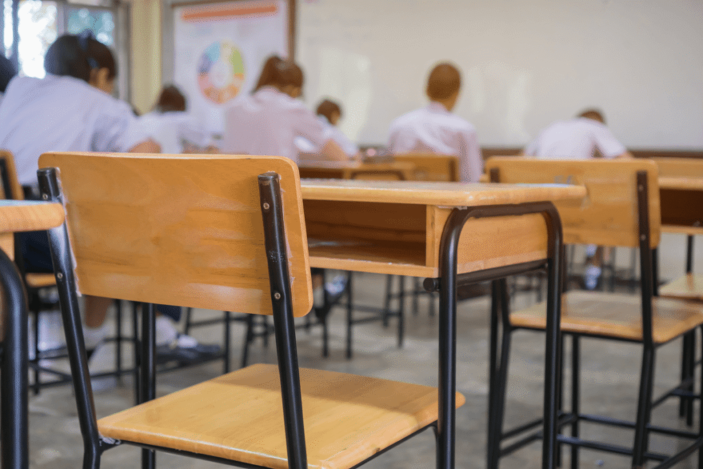 Empty classroom desk with students in the background